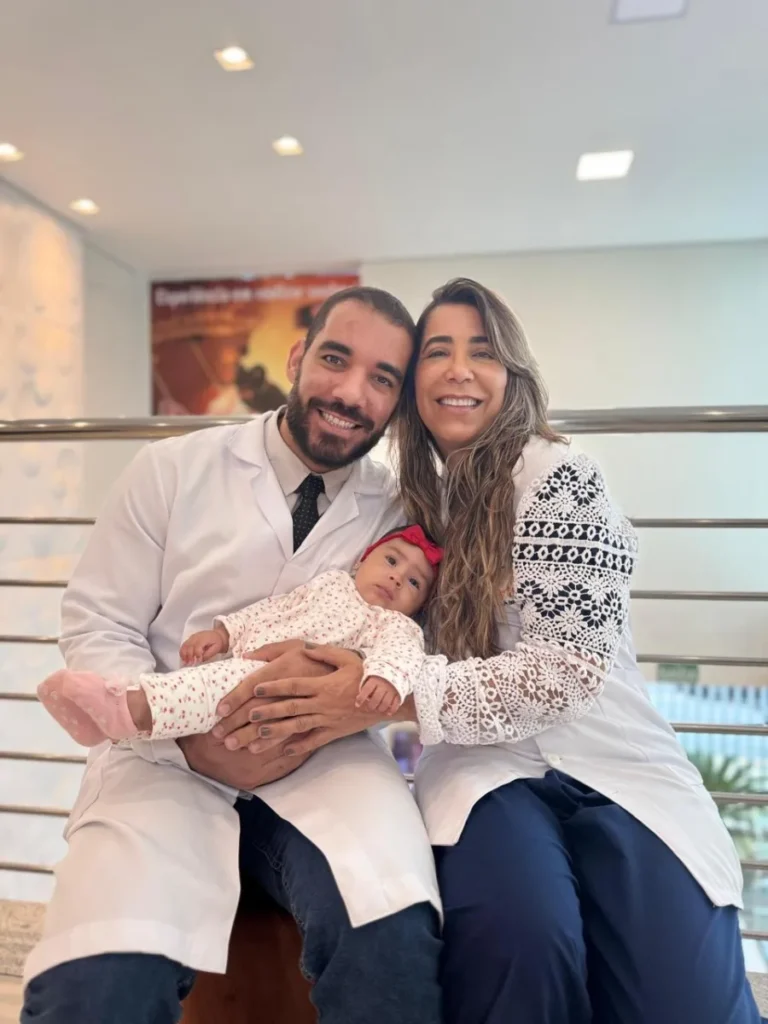 Casal com o recém-nascido ao lado de médico da Fértil