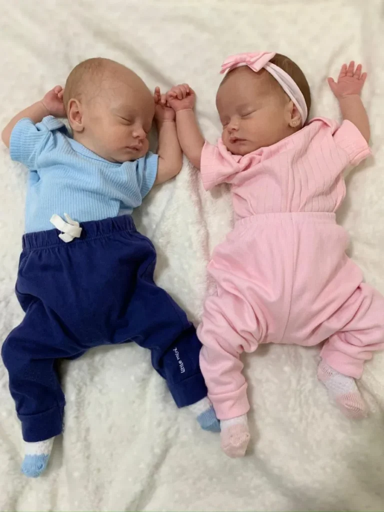 Gêmeos, menino e menina, deitados lado a lado