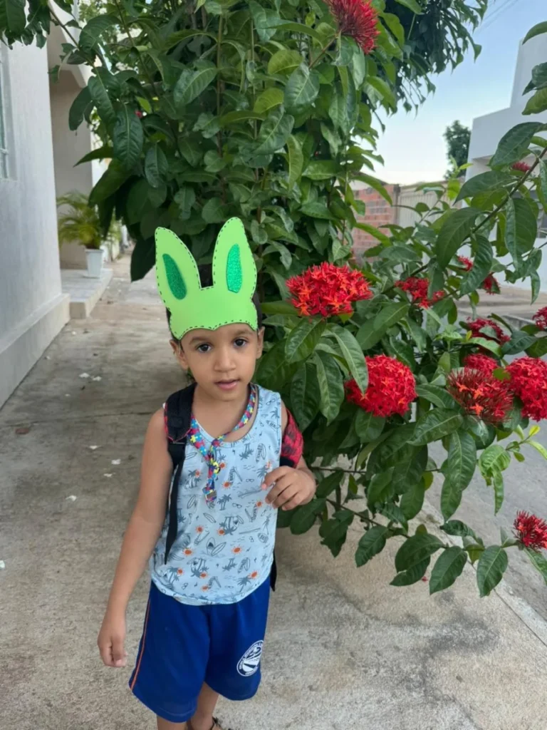 Criança com orelhas de coelho verde em jardim de rosas